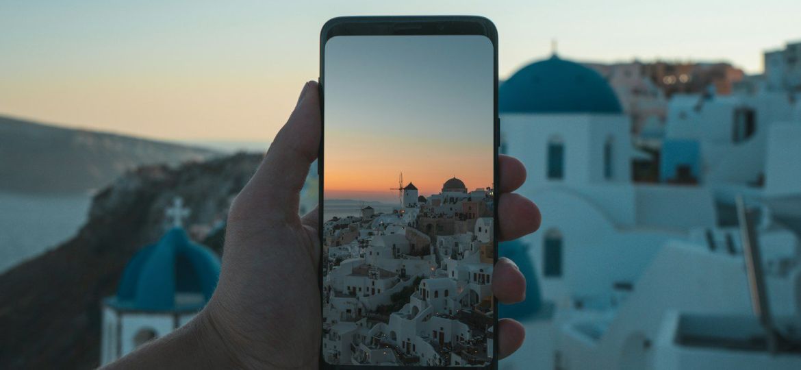person holding black smartphone taking photo of city during daytime