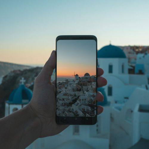 person holding black smartphone taking photo of city during daytime
