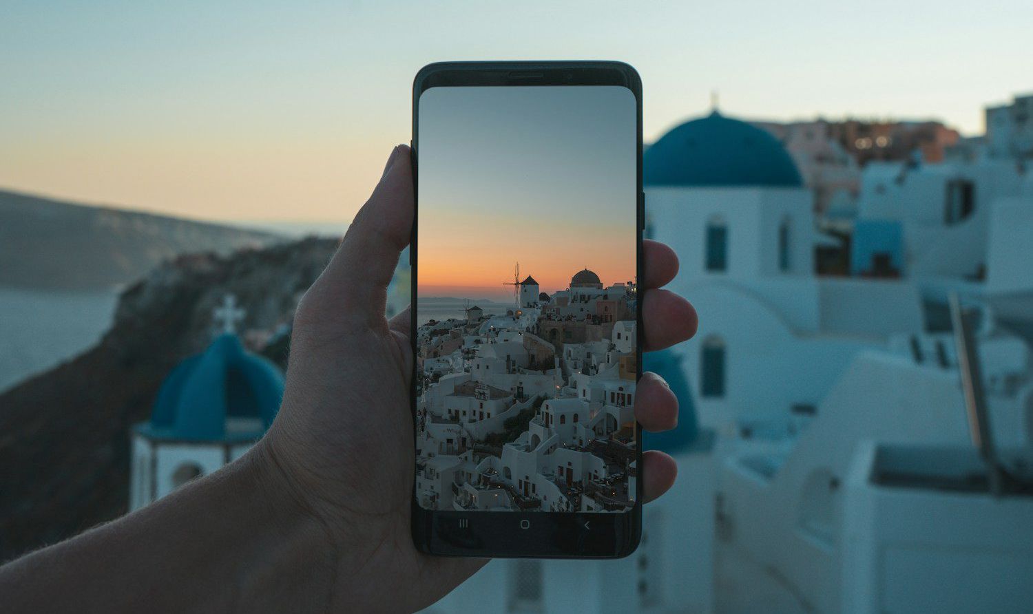 person holding black smartphone taking photo of city during daytime